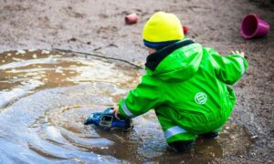 Young Boy Playing with Cars in the Mud.