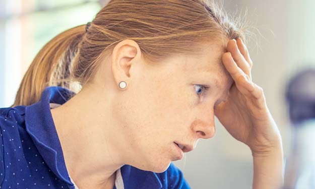 Woman Looking Stressed Leaning Forehead on Hand.